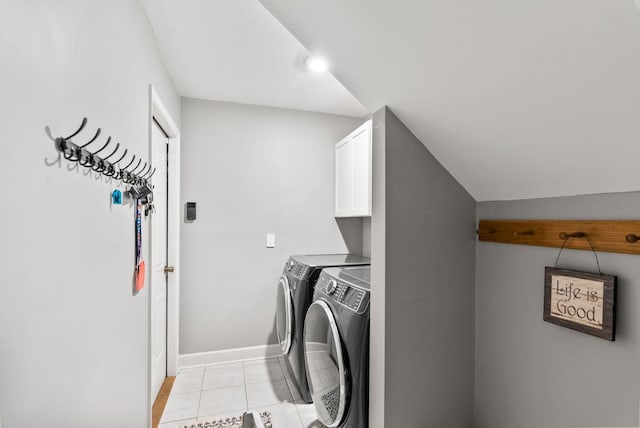 washroom featuring light tile patterned floors, cabinet space, baseboards, and separate washer and dryer