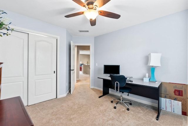 office with visible vents, baseboards, light colored carpet, and a ceiling fan