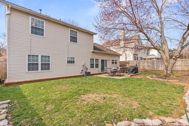 rear view of house featuring a lawn, a patio, and a fenced backyard