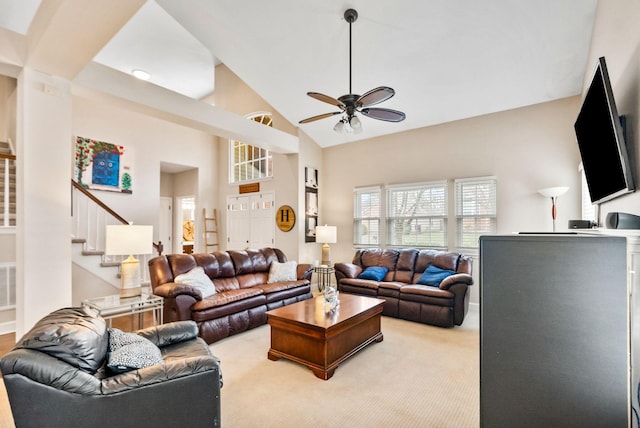 carpeted living room featuring stairway, high vaulted ceiling, and a ceiling fan