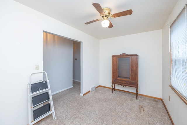 interior space with carpet floors, visible vents, ceiling fan, and baseboards