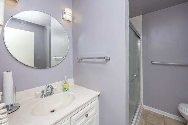 bathroom featuring toilet, vanity, a shower with shower door, and baseboards