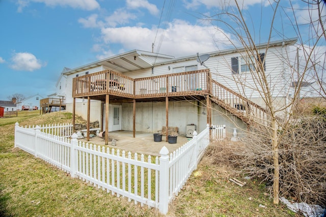 rear view of house with a patio area, a fenced backyard, a deck, and a lawn