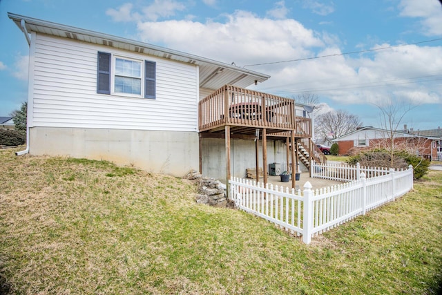 rear view of house with stairway, fence, a lawn, and a wooden deck