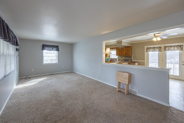 interior space featuring a ceiling fan, light carpet, visible vents, and baseboards