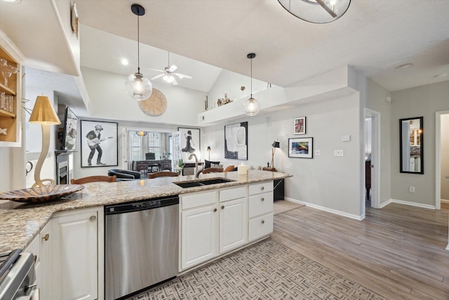 kitchen featuring open floor plan, range, stainless steel dishwasher, white cabinets, and a sink