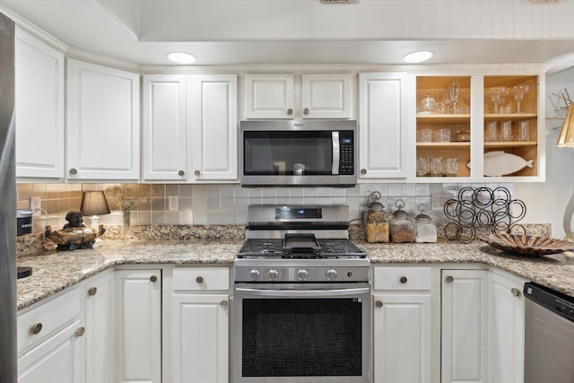 kitchen with tasteful backsplash, recessed lighting, white cabinets, and stainless steel appliances