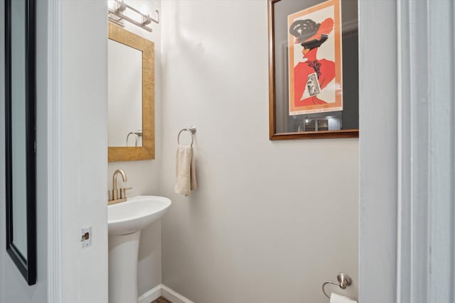 bathroom featuring baseboards and a sink