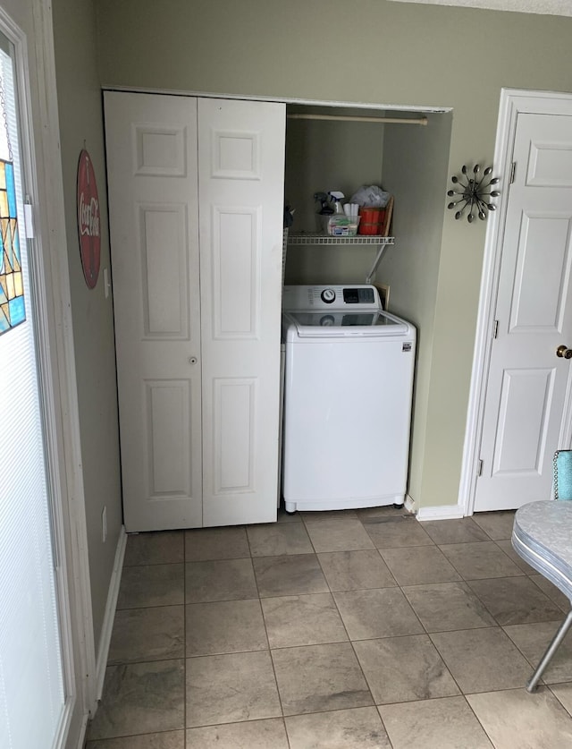 clothes washing area featuring washer / dryer, laundry area, and baseboards