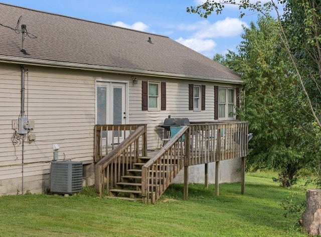 rear view of house featuring a shingled roof, central AC unit, a lawn, stairs, and a deck