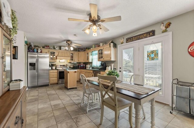 dining room with ceiling fan, a textured ceiling, and light tile patterned floors