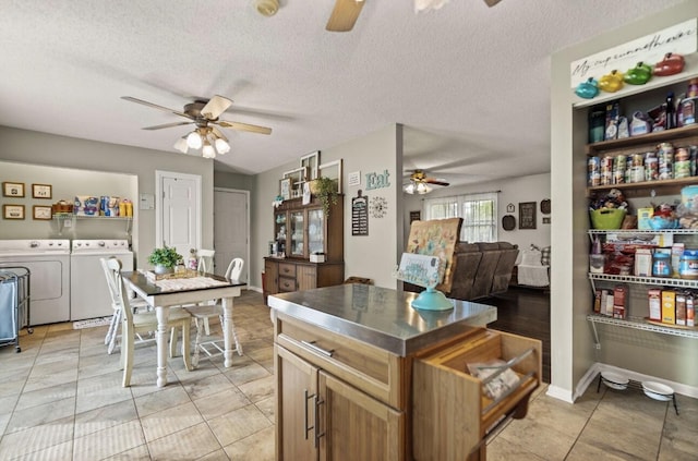 kitchen with a ceiling fan, open floor plan, a textured ceiling, and washing machine and clothes dryer