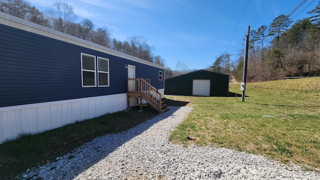 view of yard featuring an outbuilding, driveway, and a detached garage