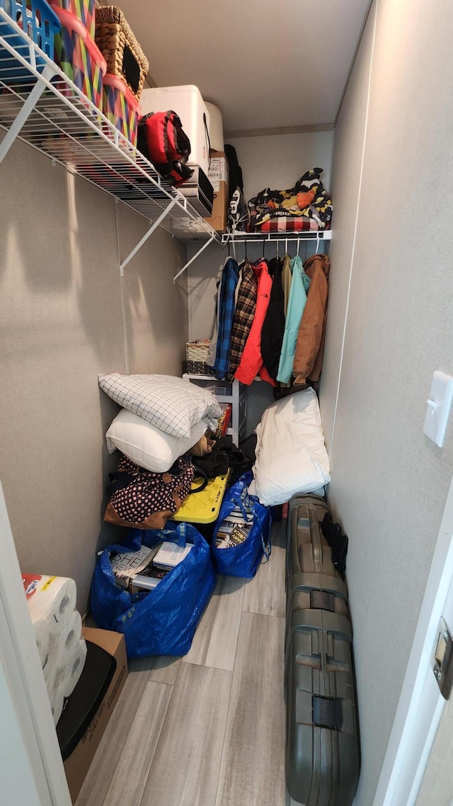 walk in closet with wood finished floors