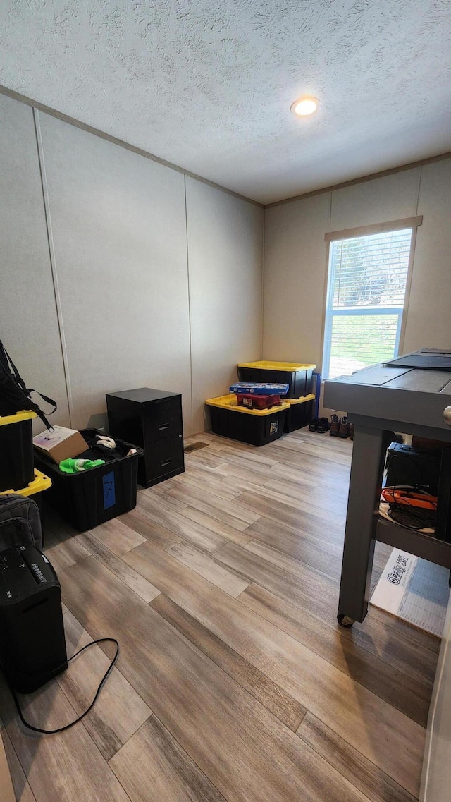 interior space with a textured ceiling and wood finished floors