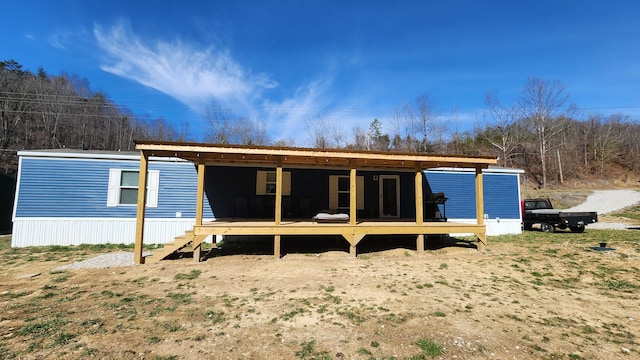 rear view of property featuring a wooden deck