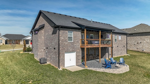 back of house featuring an outdoor fire pit, a lawn, a patio, roof with shingles, and brick siding