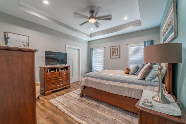 bedroom featuring ceiling fan, recessed lighting, wood finished floors, ornamental molding, and a raised ceiling