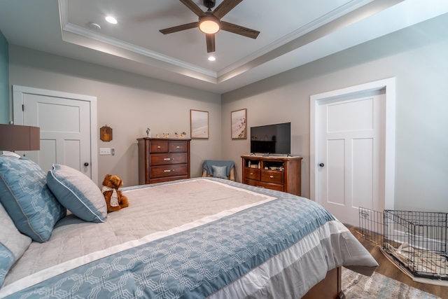 bedroom featuring a tray ceiling, crown molding, recessed lighting, ceiling fan, and wood finished floors