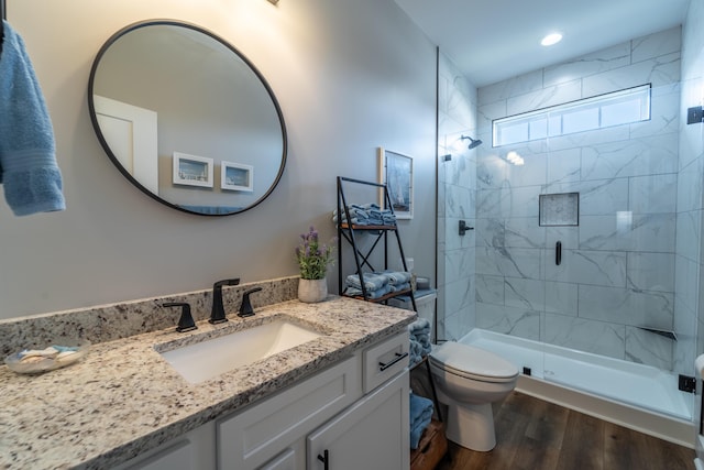 full bathroom featuring toilet, recessed lighting, wood finished floors, vanity, and a shower stall