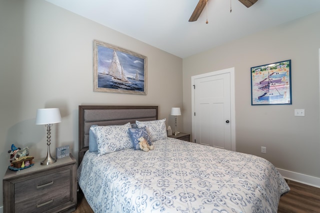 bedroom with dark wood-style floors, ceiling fan, and baseboards