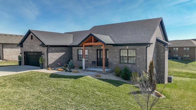 view of front facade featuring a front yard, brick siding, driveway, and roof with shingles