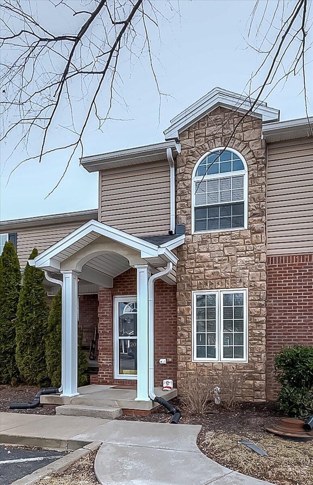 property entrance with stone siding and covered porch