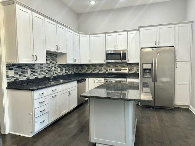 kitchen with stainless steel appliances, tasteful backsplash, dark wood-style flooring, and a sink