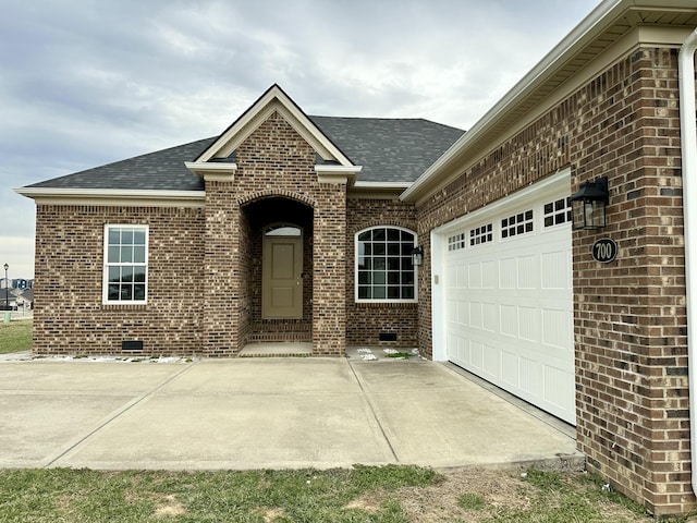 view of front of house with a garage, brick siding, driveway, and roof with shingles