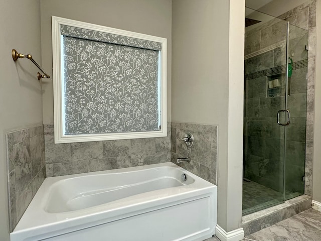 bathroom with marble finish floor, a stall shower, and a bath