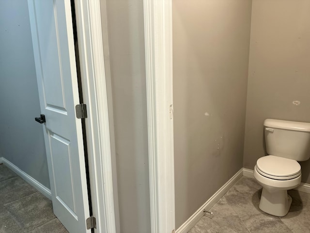 bathroom with baseboards and toilet