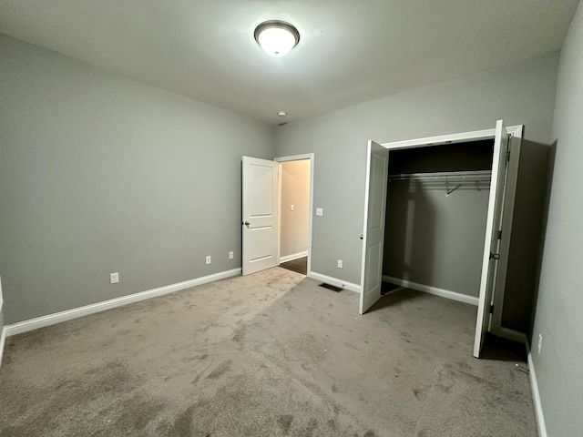 unfurnished bedroom featuring a closet, carpet, visible vents, and baseboards