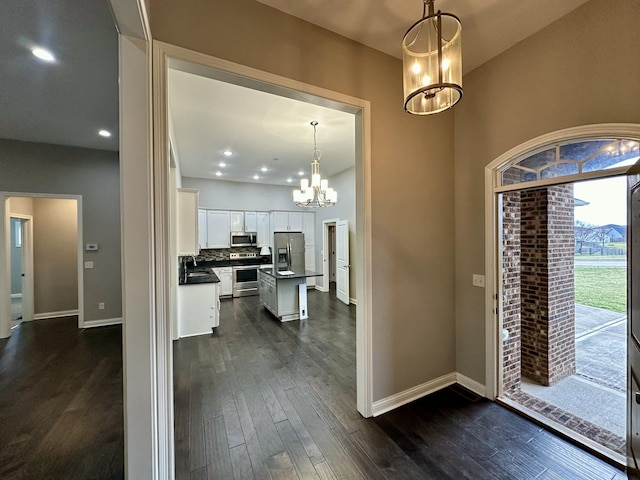 foyer with dark wood-style floors, recessed lighting, a notable chandelier, and baseboards