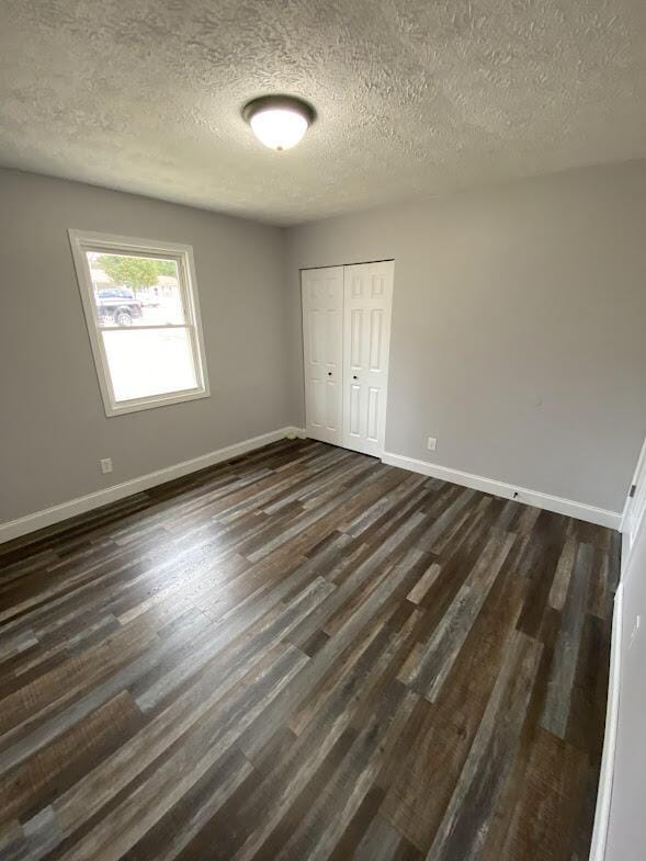 109 Homestead, London, KY 40741 - unfurnished bedroom with baseboards, a textured ceiling, dark wood-style floors, and a closet