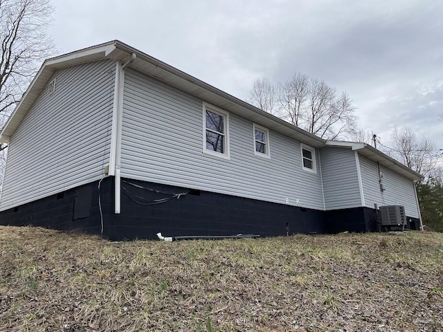 view of property exterior with crawl space and central air condition unit