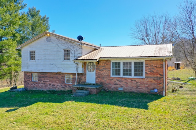 split level home with metal roof, brick siding, crawl space, and a front yard