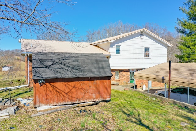 rear view of property with an outbuilding, brick siding, a lawn, and a storage shed