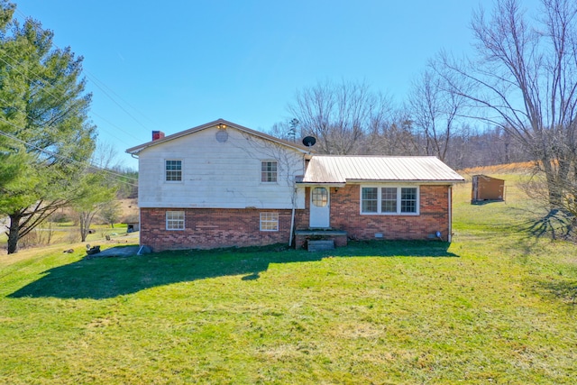 view of front of home featuring metal roof, a front lawn, crawl space, and brick siding