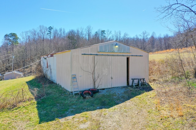 view of pole building with driveway and a lawn