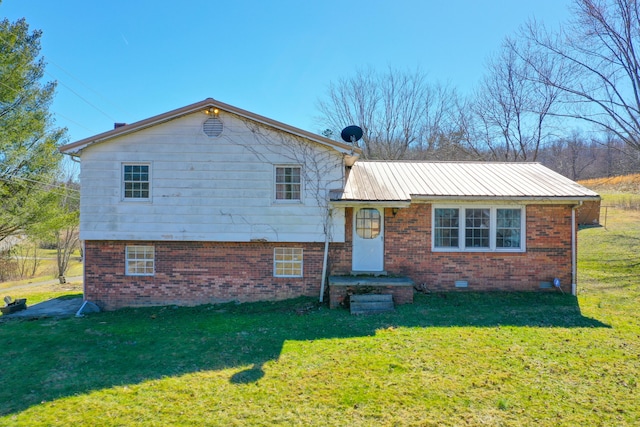 split level home featuring crawl space, brick siding, metal roof, and a front yard