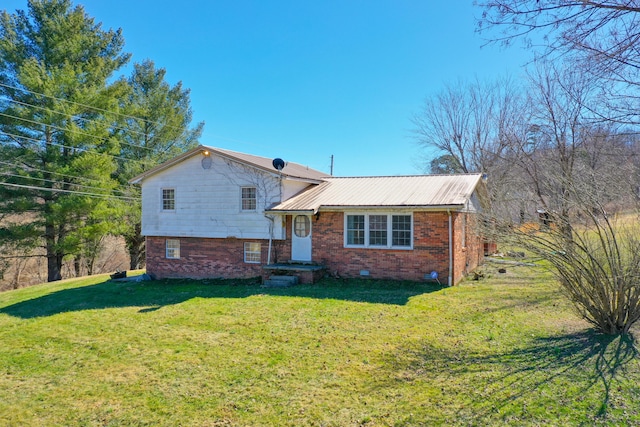 view of front of property with crawl space, a front yard, metal roof, and brick siding