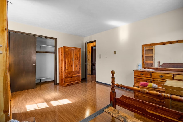 bedroom featuring a closet, baseboards, and wood finished floors