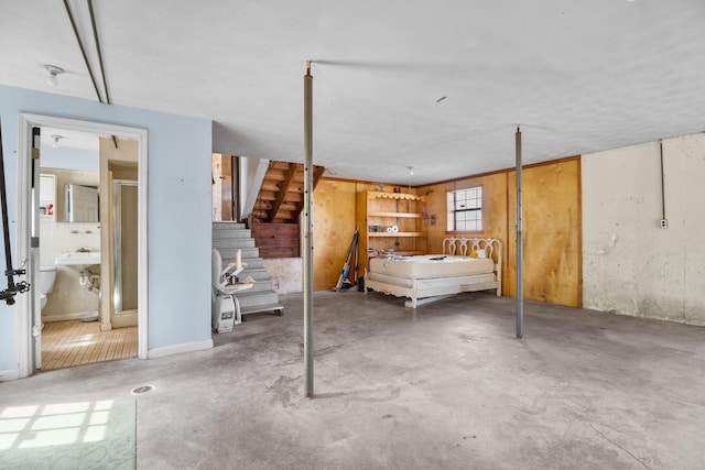 unfurnished bedroom with a sink, concrete flooring, and ensuite bathroom