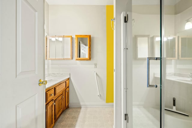 bathroom with a shower stall, baseboards, and vanity