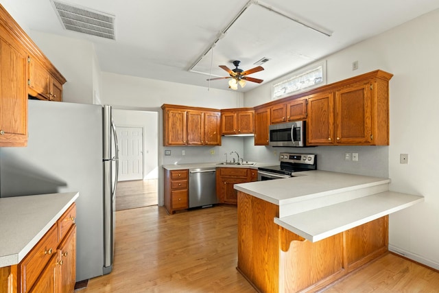 kitchen with visible vents, appliances with stainless steel finishes, a ceiling fan, a sink, and a peninsula