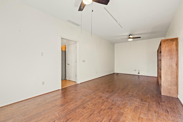 spare room featuring baseboards, ceiling fan, visible vents, and wood finished floors