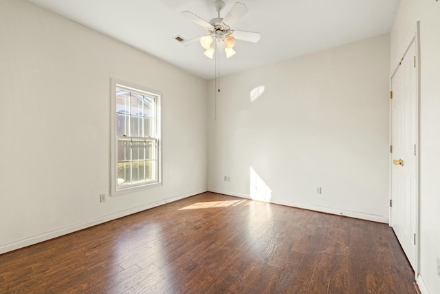 spare room with ceiling fan, visible vents, hardwood / wood-style flooring, and baseboards