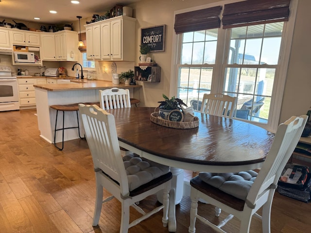 dining space with wood finished floors and recessed lighting