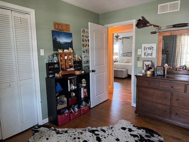 bedroom with dark wood-style flooring, visible vents, baseboards, and multiple windows