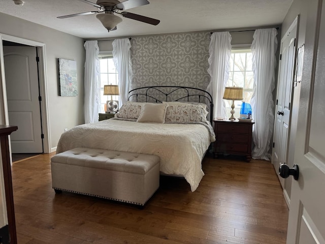 bedroom featuring wood-type flooring, a textured ceiling, and baseboards